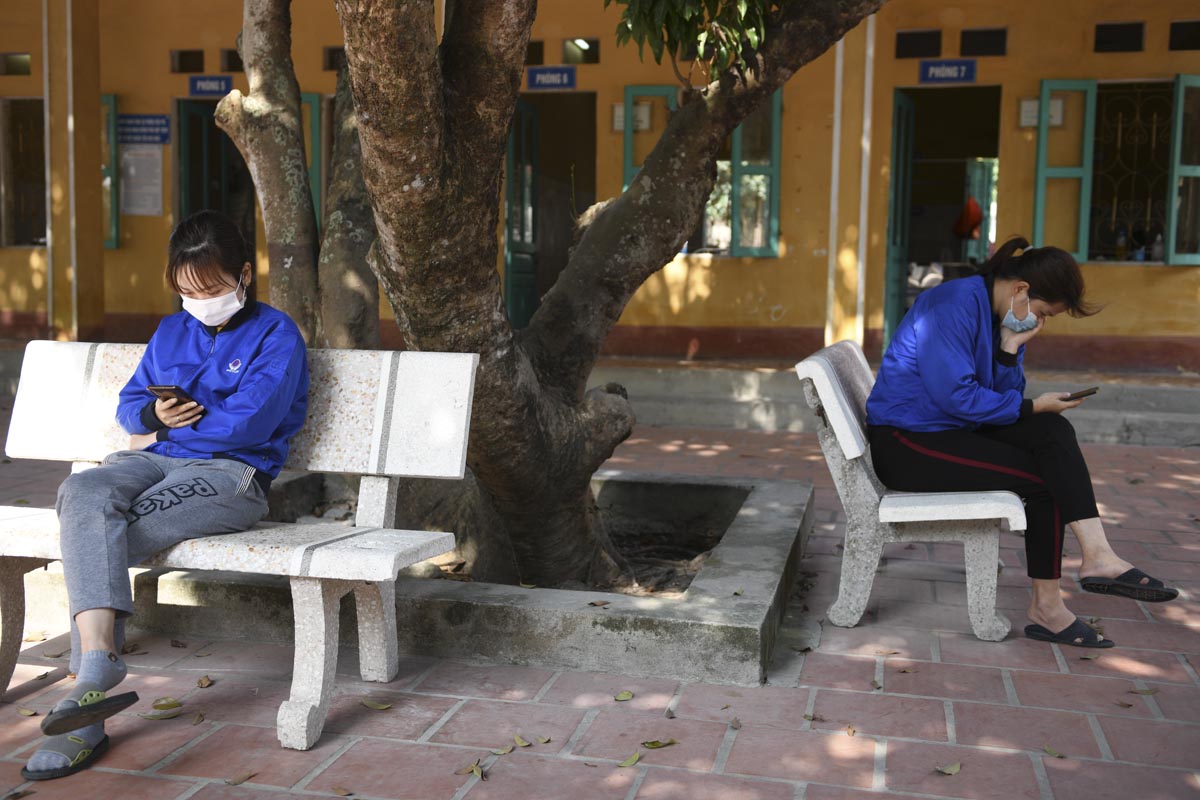 Social distancing of two woman sitting on seperate benches
