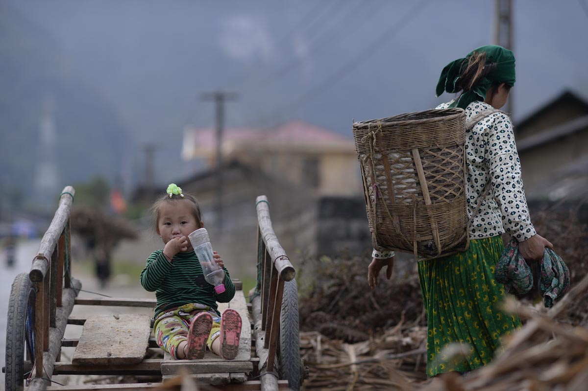 Woman working with young girl on cart 