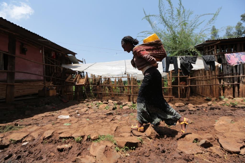 Girl carrying water cans