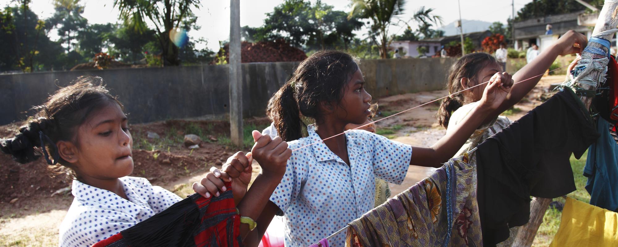 Girls hanging washing on a line