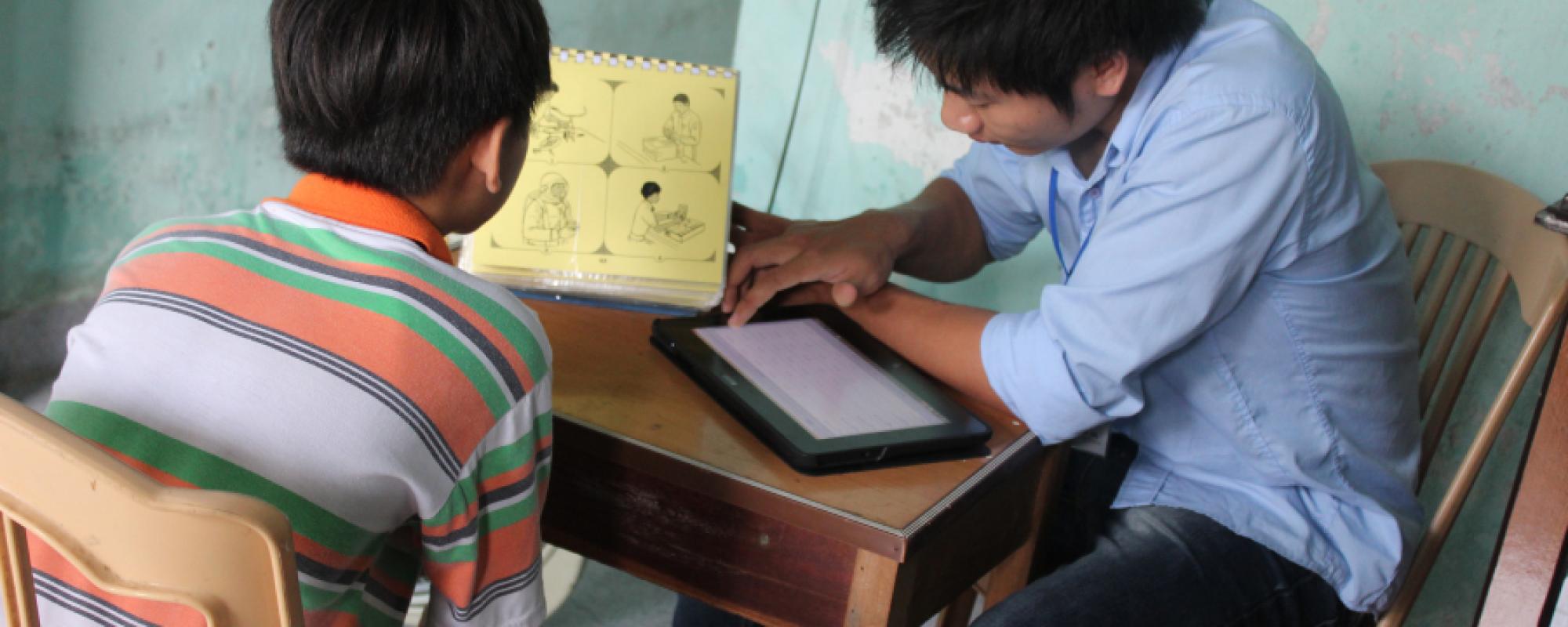 teenage boys sitting at the table with a tablet 