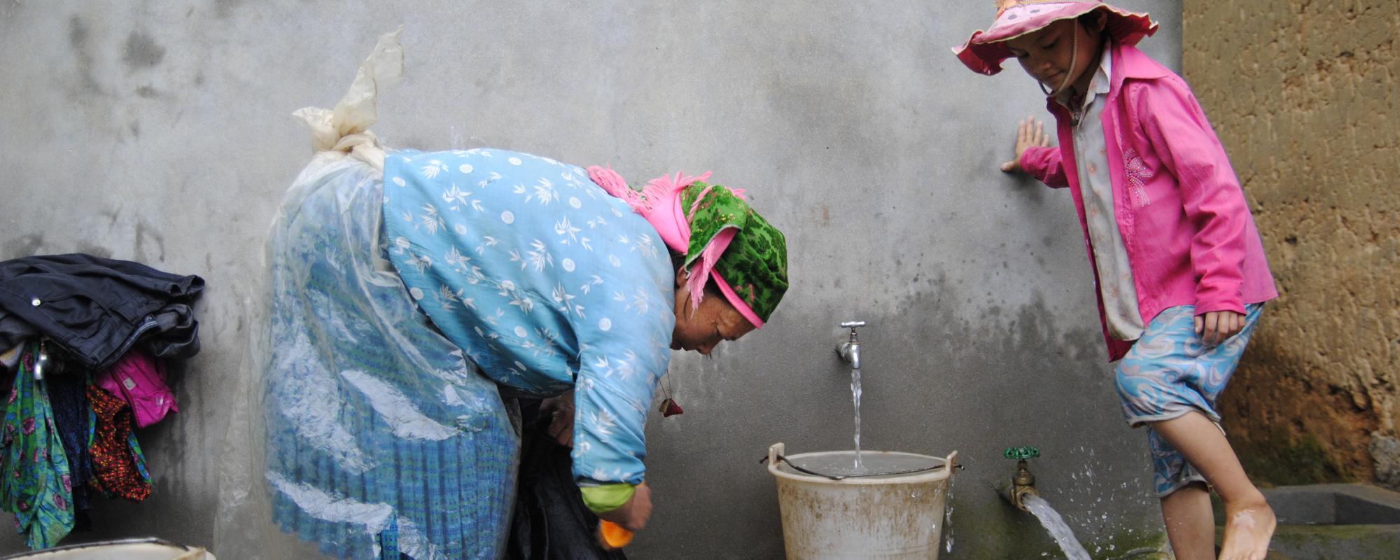 women and girl hand washing clothes 