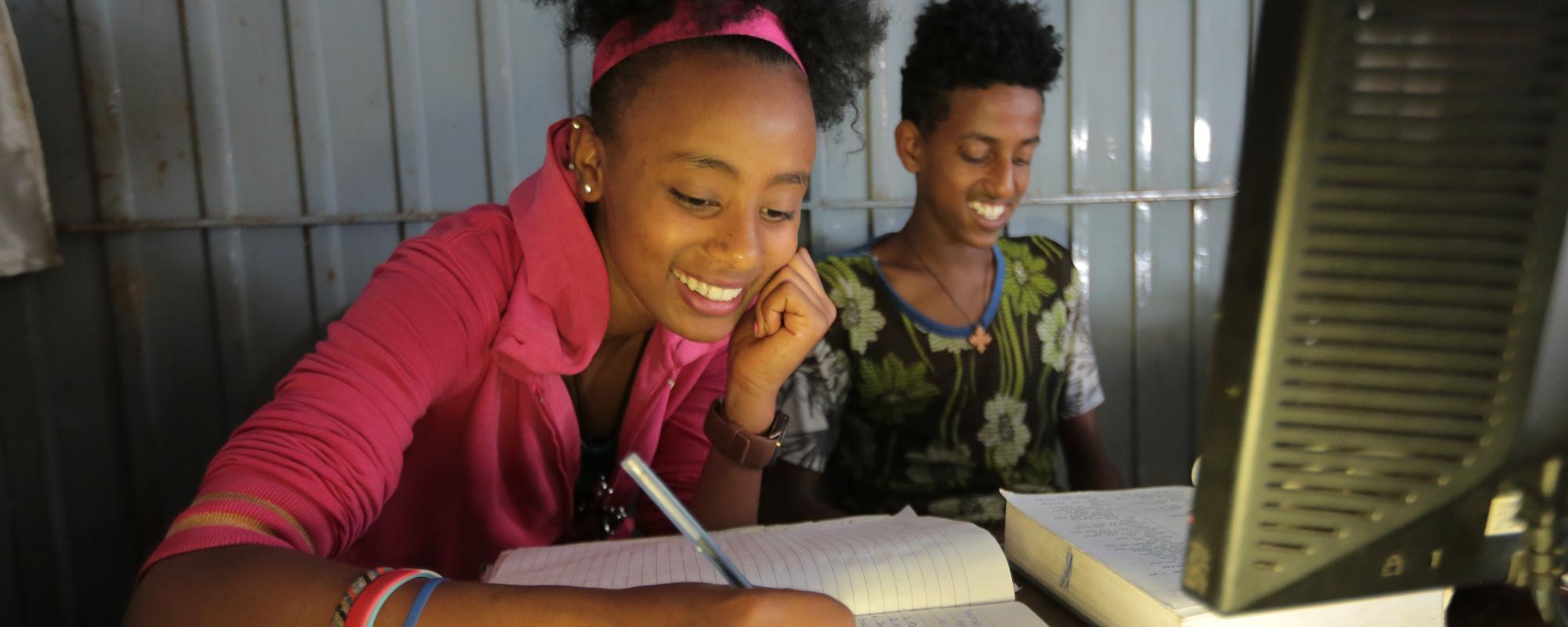 girls writing in exercise book