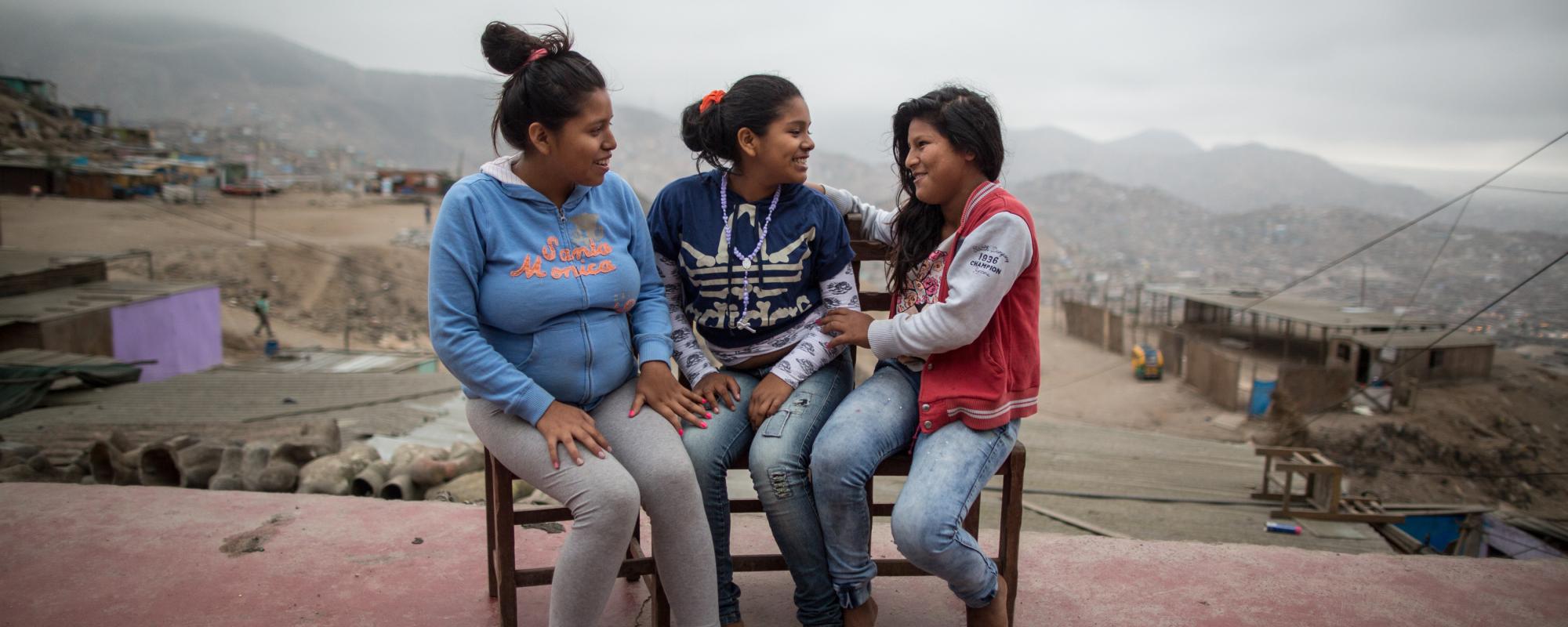 Three young girls sitting on a bench