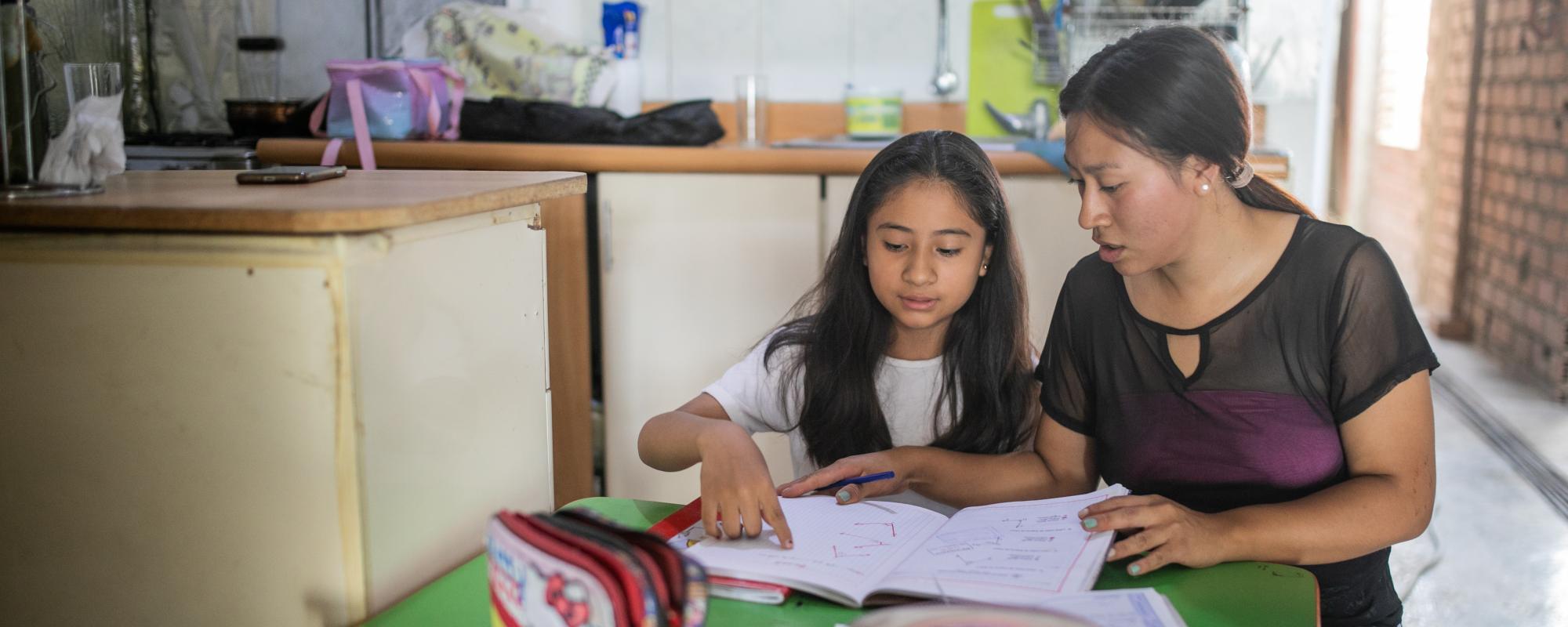 Older girl tutoring younger girl