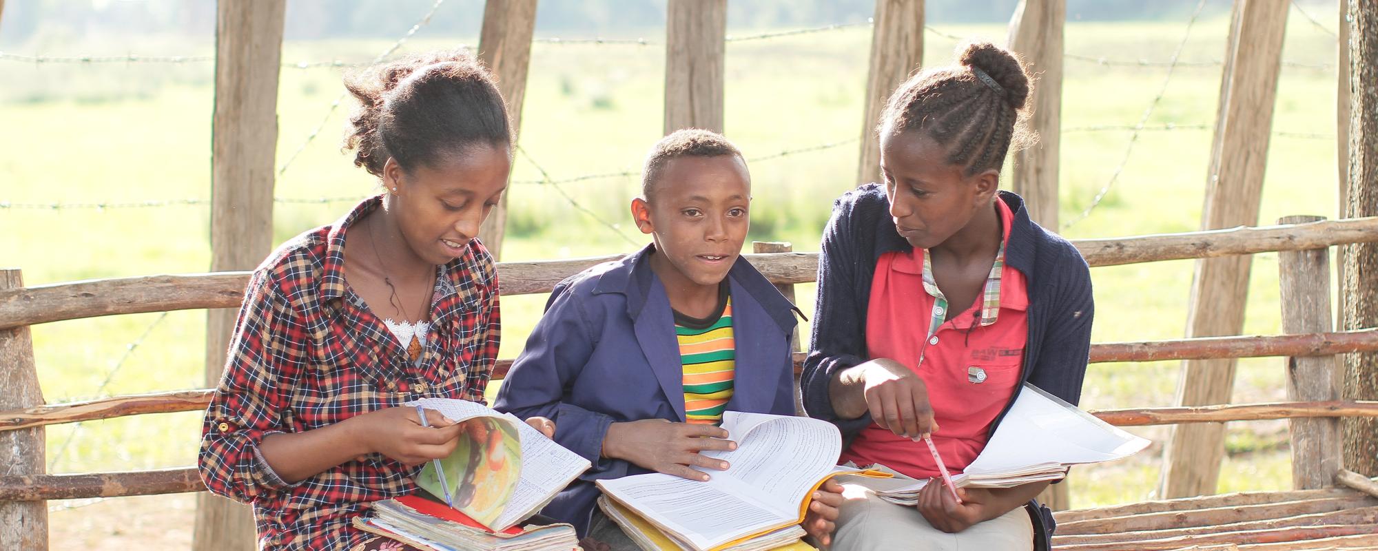 Three children with schoolwork