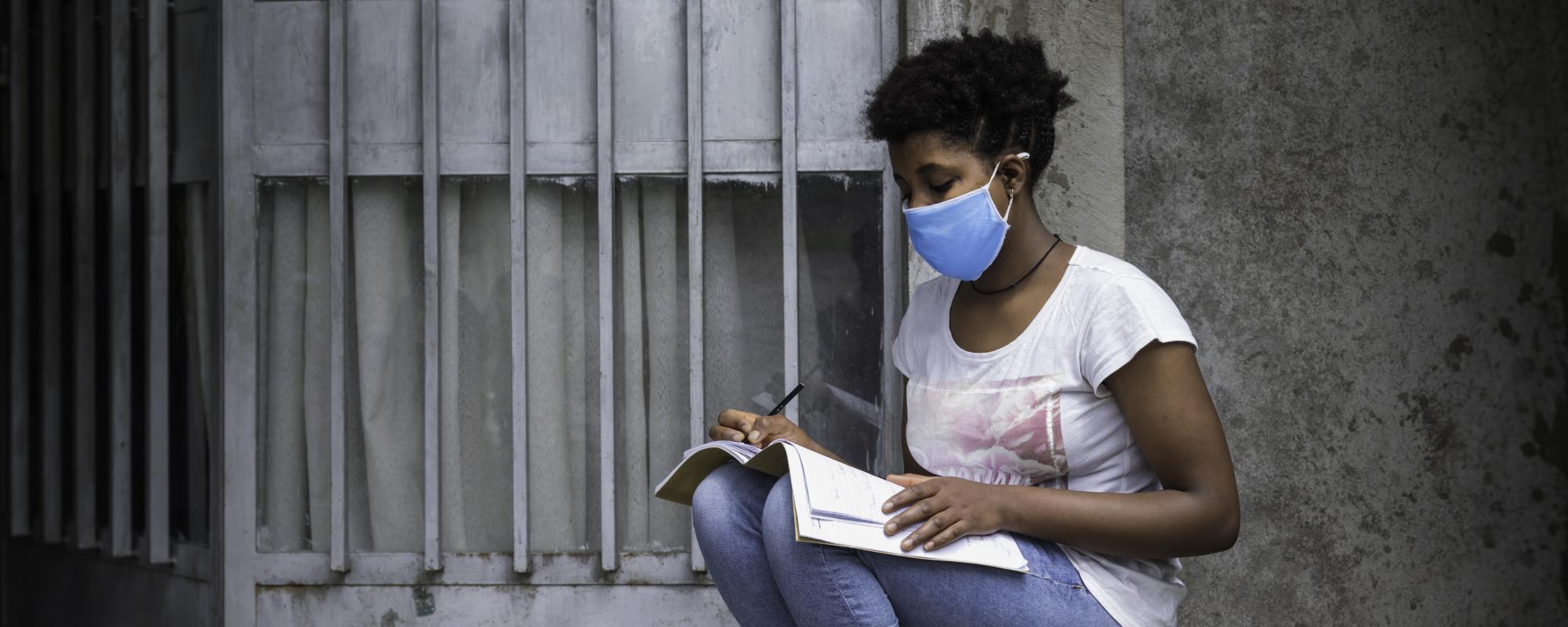 Girl studying outside in a mask
