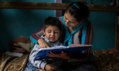 mother reading to child on bed