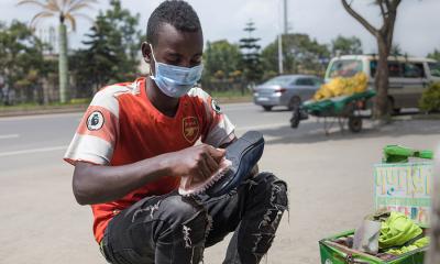 man cleaning shoes on a street