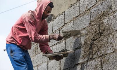 Man in a red hoodie, brick laying