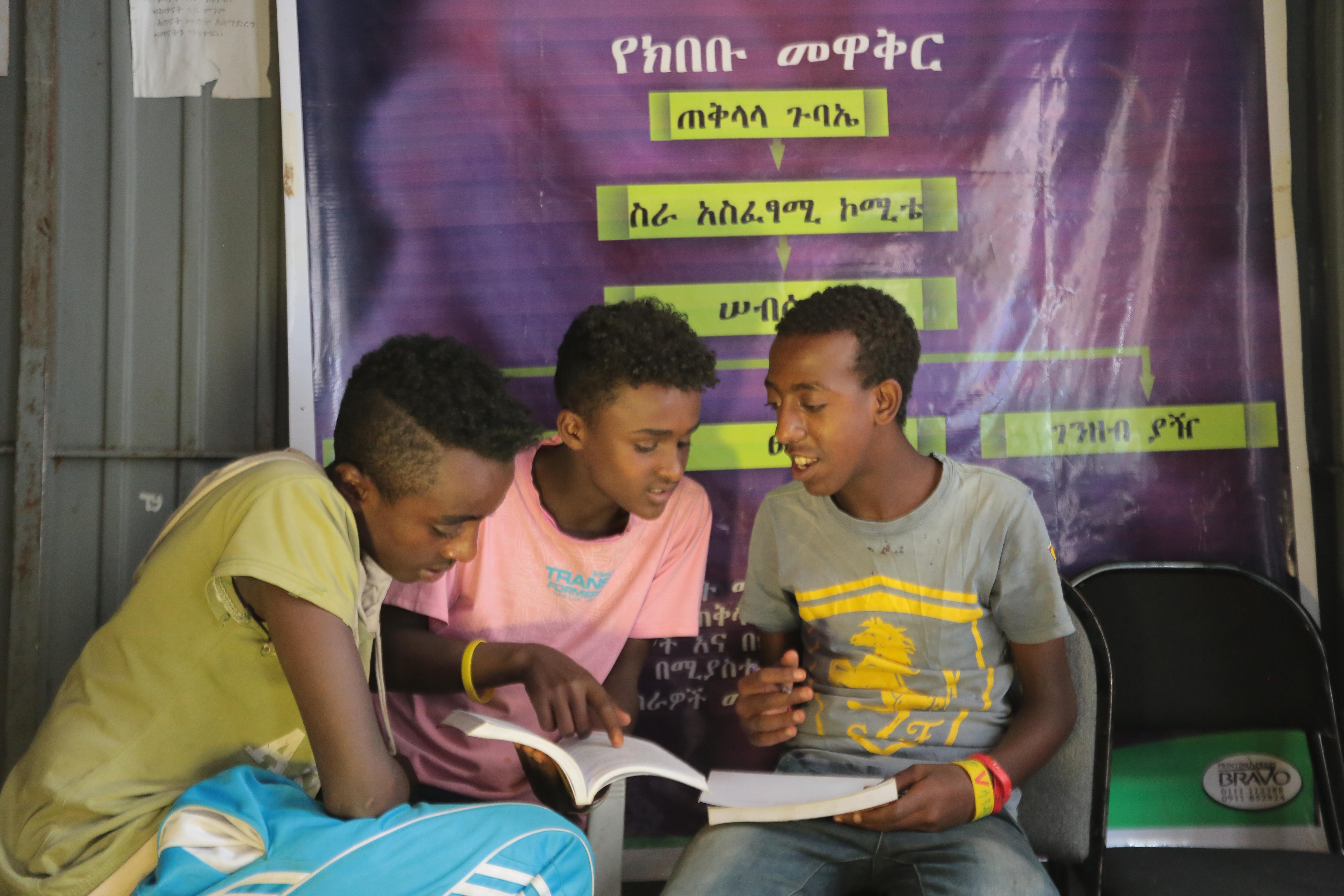 boys sat sharing a book