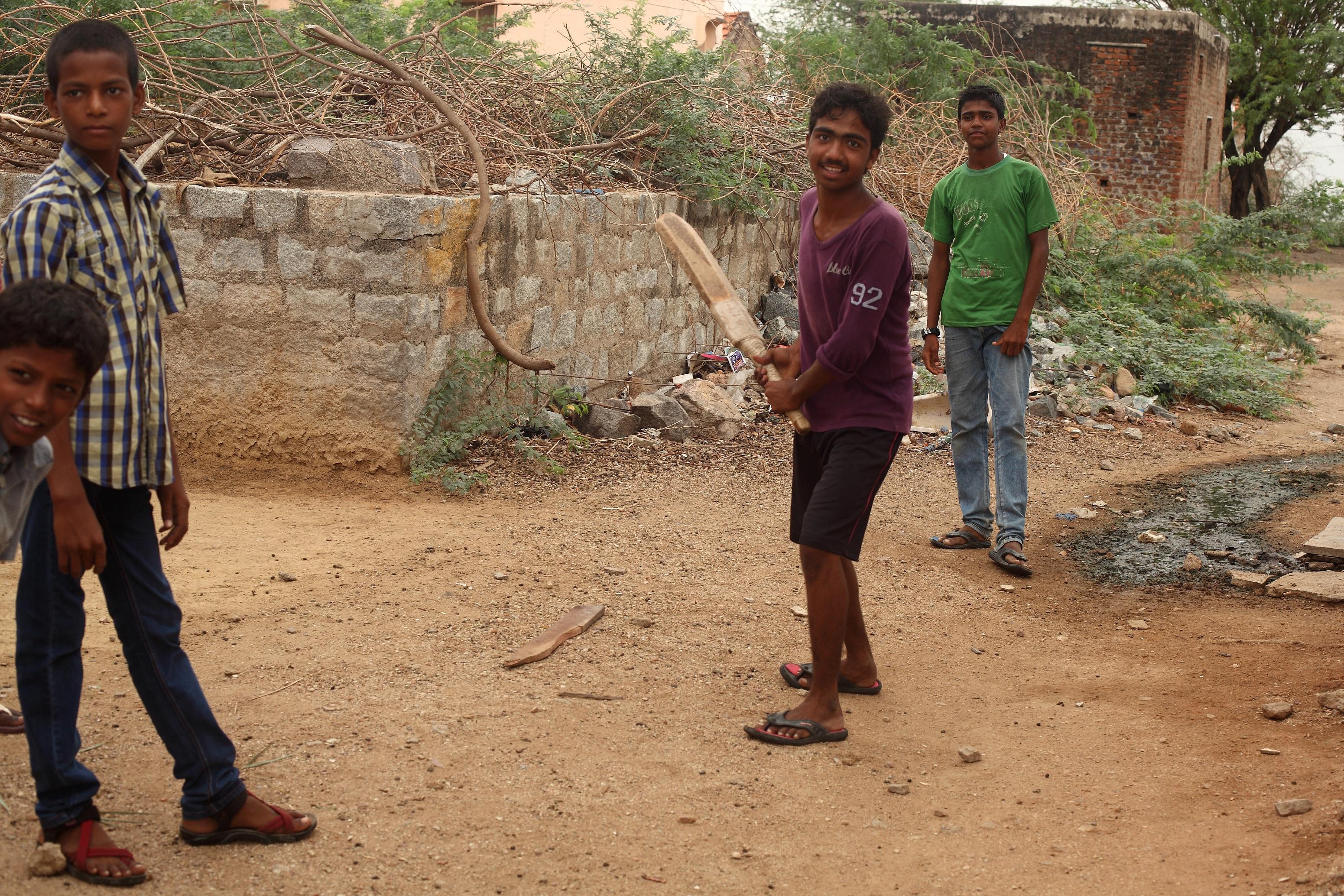 three men playing cricket