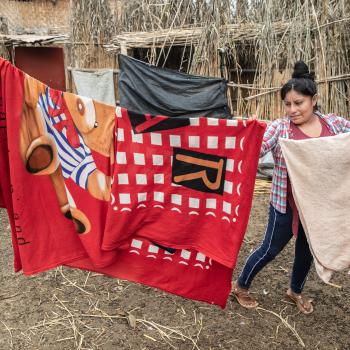 Woman hanging up sheets on a line 