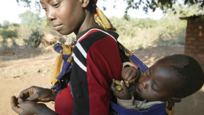 women carrying her baby in a sling on her back