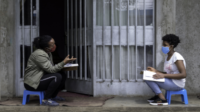 women in masks talking to one another 