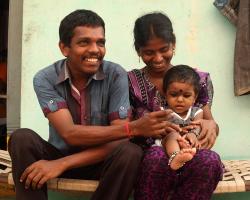 a father, mother and baby sitting together