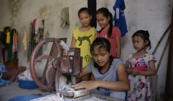 Children using a piece of sewing equipment