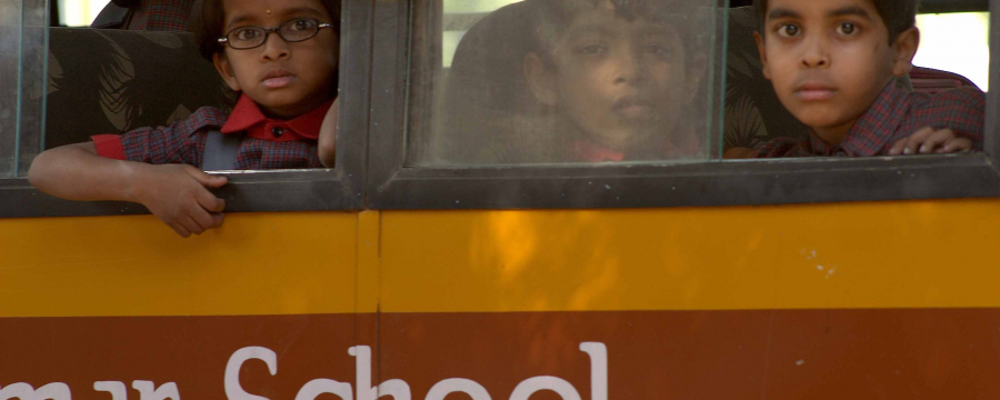 Children looking out the window of a school bus